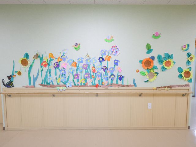 カラフルな壁面装飾の廊下 廊下 壁にはカラフルで元気な印象の花の装飾が施されており、明るい雰囲気の廊下です。装飾を眺めながらの散策も楽しめそうです。