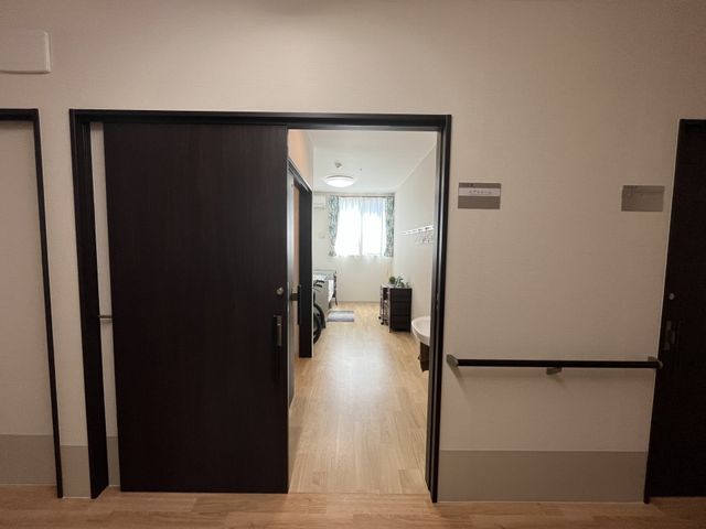 居室のドア開口部 居室 ゆったりとした開口部があり、室内は落ち着いた色合いで整えられています。安心して新たな生活を始められる空間です。