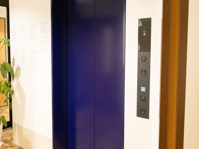 広々としたエレベーター エレベーター 落ち着いた色合いのエレベーターは、移動を楽にするために設計されています。扉の横にはわかりやすく操作できるボタンがあります。
