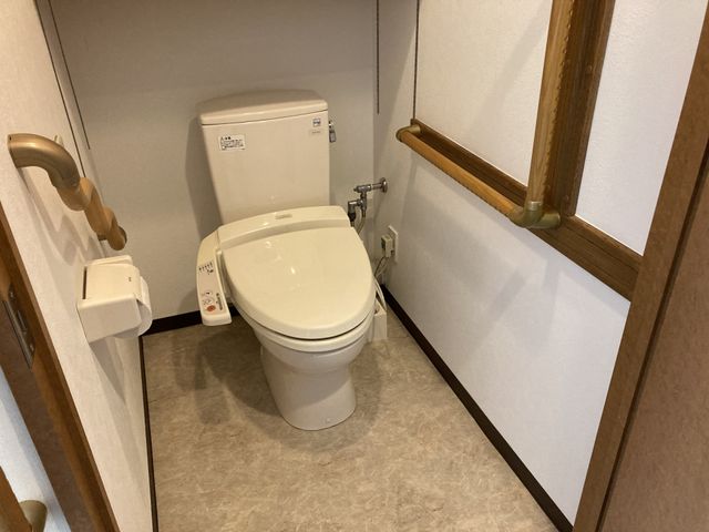 便利なトイレ設備 トイレ 手すり付きのトイレで、安心して使える安全な設計です。清潔感ある空間になっています。