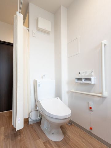 トイレの清潔な空間 トイレ 手すり付きのトイレは安全で清潔感があり、快適な使い心地を想像できます。