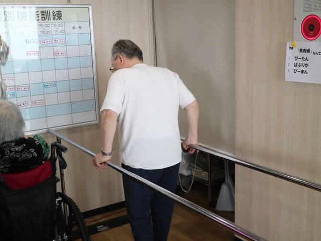 バランス訓練中の様子 機能訓練室 手すりを利用しながらバランスを取りながら歩行訓練をしている様子が見られます。安全で心地よい環境が整っています。