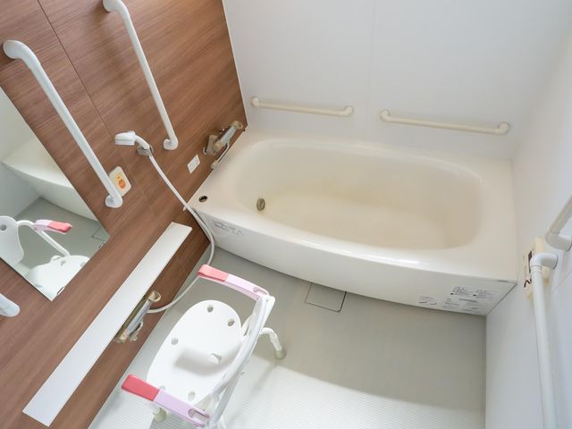 手すり付き浴室 浴室 手すりが複数設置された、移動に配慮しやすい浴室です。入浴用のいすもあり、介助しやすそうなつくりです。