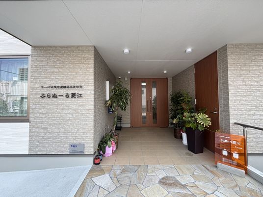 木製ドアと植栽のエントランス