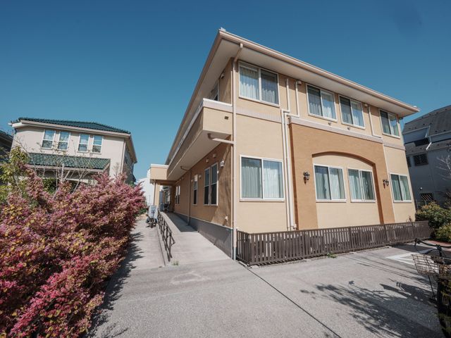 陽光差し込む外観 外観 自然光に包まれた、大きな窓が印象的な建物です。周囲には植物が彩りを添えています。