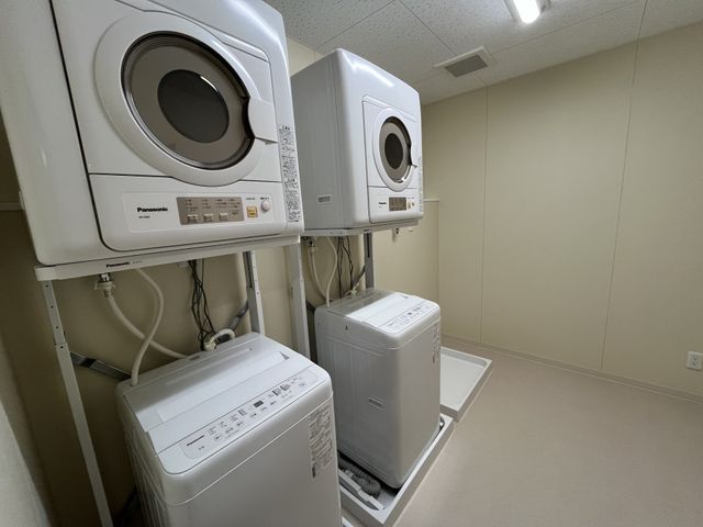 洗濯機が並ぶ部屋 コインランドリー シンプルで使いやすいランドリースペースです。複数台の洗濯機で効率的に作業ができます。