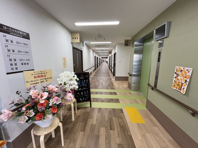 長い廊下 廊下 広々とした廊下は、明るい色のフロアと案内表示があり、移動しやすく工夫されています。