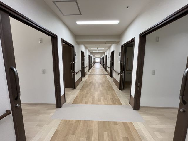 長い廊下の静かな風景 廊下 広々とした廊下が続いています。落ち着いた雰囲気で、職員の動きもスムーズです。