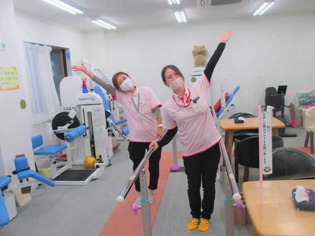 笑顔のスタッフと機器の部屋 機能訓練室 スタッフが親しみやすい環境で機器を説明しています。明るく快適な空間で働けます。