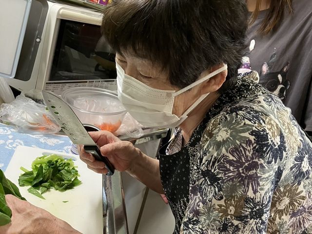 調理の様子を伝える居室 キッチン サポートを受けながら野菜を切る方の姿です。あたたかい雰囲気の中での料理は心を豊かにします。