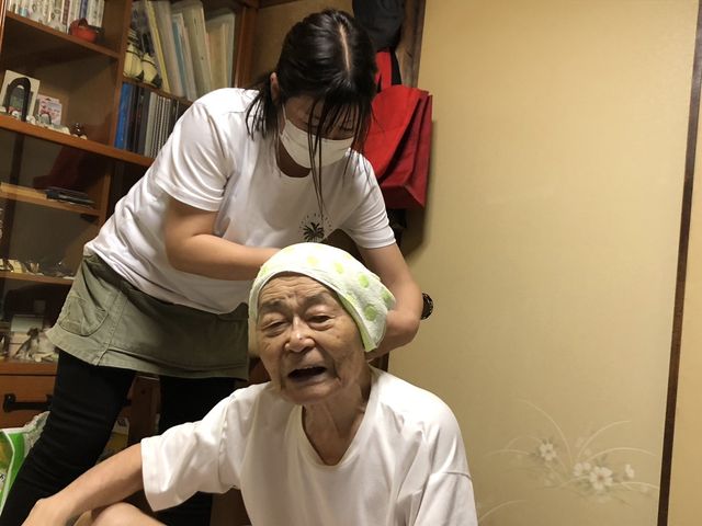 介護の手を受ける高齢の方 理美容室 手厚いケア体験をする高齢者の方々。安心してゆったりと日々をお過ごしいただける環境です。