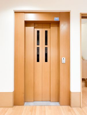 木目調エレベーターの前
