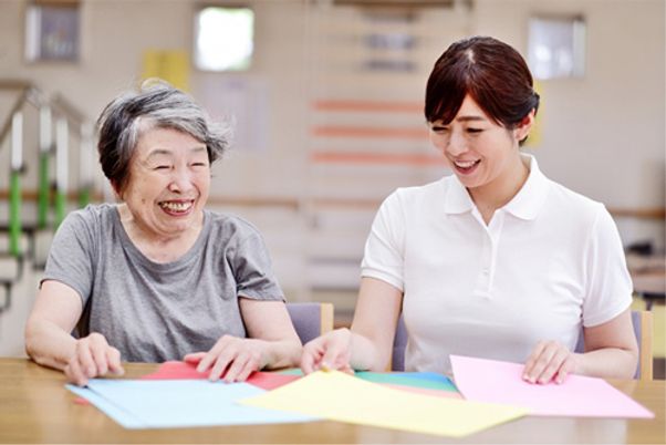 笑顔で工作する利用者とスタッフ