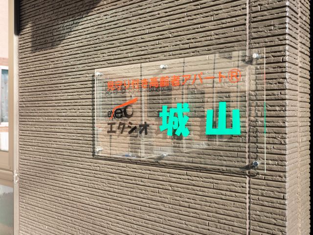 看板のデザイン 看板 建物の外壁に掲げられた看板です。施設の名前が明記されており、存在感があります。