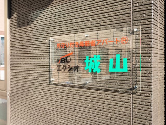 看板のデザイン 看板 建物の外壁に掲げられた看板です。施設の名前が明記されており、存在感があります。