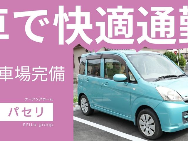 送迎車の駐車場 外観   車で快適通勤と大きく掲示され、送迎用と思われる車が停まっています。駐車場が整っており、通勤時の出入りがしやすそうです。
