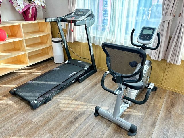 機能訓練機器のある部屋 機能訓練室   窓から光が入る明るい空間に、ランニングマシンとエアロバイクが並んでいます。運動しやすい環境づくりが伝わります。
