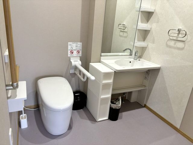 手すり付きトイレ洗面台 トイレ   手すりが設置された清潔感のあるトイレです。洗面台も近く、使いやすさに配慮されたつくりです。