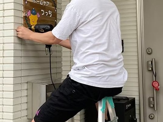 機器を操作する人と玄関  