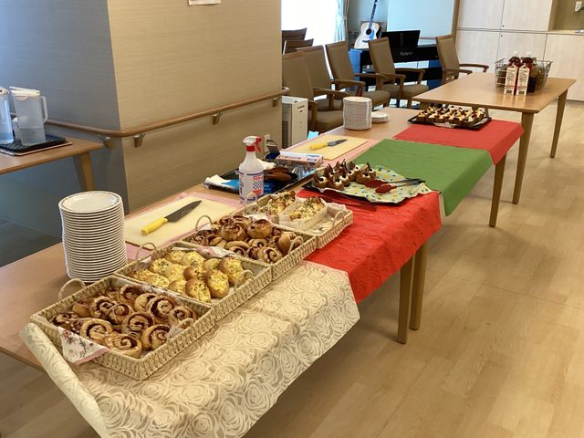 焼き菓子の並んだテーブル ダイニングルーム 焼き菓子が並ぶテーブルがあり、アクティビティの準備が整っています。食の楽しみを支える空間です。
