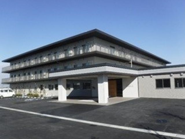 介護施設の外観 外観   白い外壁と大きな庇が印象的な建物です。駐車スペースも見え、落ち着いた雰囲気です。