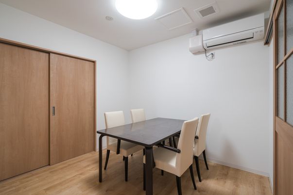 壁のエアコンと食卓の部屋