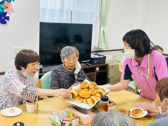 パンを手渡すダイニングルーム