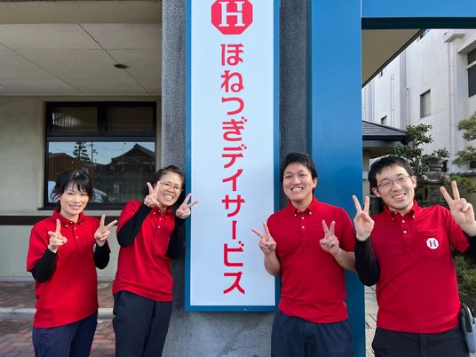 笑顔のスタッフと看板  