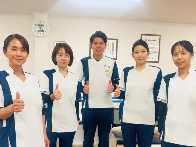 スタッフイメージ スタッフイメージ スタッフが親指を立てて笑顔で立っています。温かくフレンドリーな職場環境が感じられます。