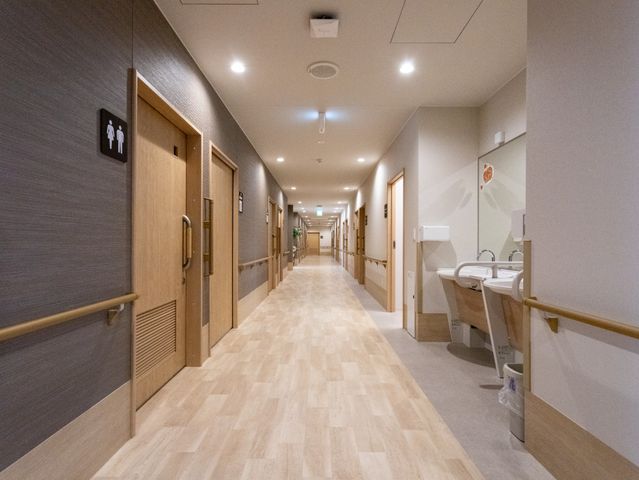 明るい廊下 廊下 手すりが設置された廊下は、移動がしやすく安全性に配慮されています。明るい照明で快適です。