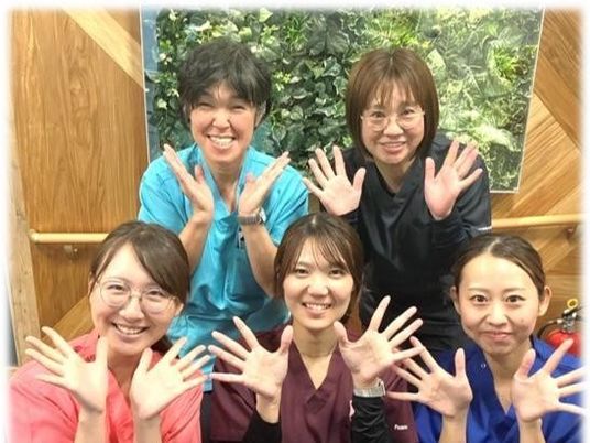 笑顔のスタッフ5人が並ぶロビー  