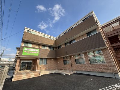 駐車スペースと入口の建物外観