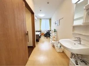 居室の洗面台とベッド  