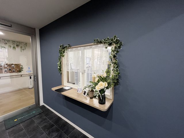 受付の花飾り フロント 緑の葉と花が美しく飾られたカウンターが迎えます。温かみのある雰囲気のエントランスです。