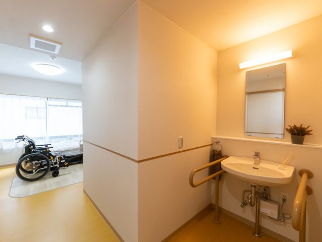 清潔な洗面台のある居室 居室 温かみのある空間に洗面台を備えた居室です。自然光が差し込む快適な空間が魅力です。