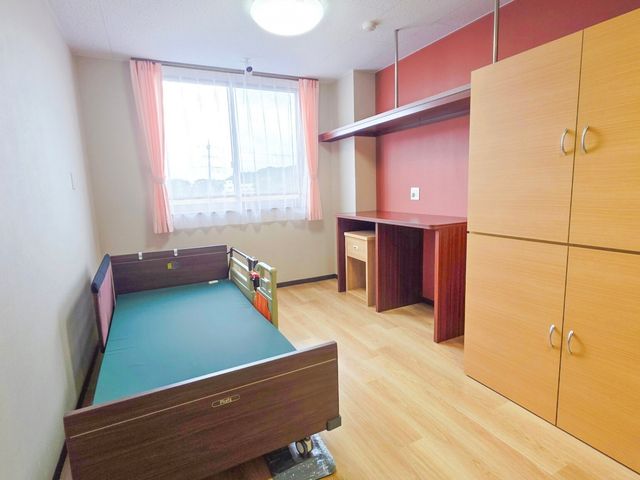 一人部屋の居室 居室 窓から自然光が差し込む明るい一人部屋です。木目調の床と家具が温かみを演出しています。