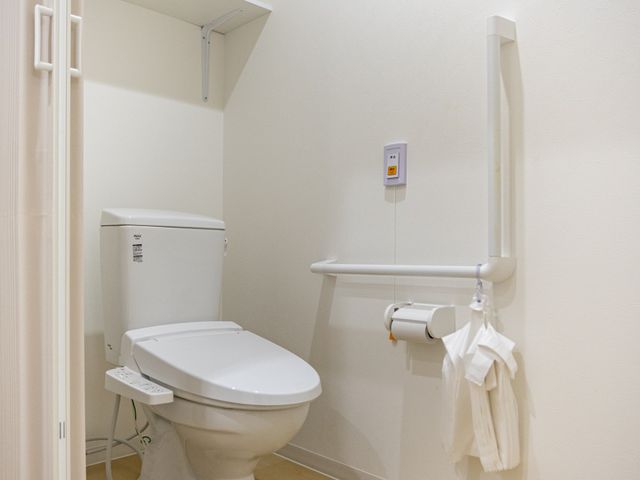 手すり付きトイレ トイレ   手すりが複数あり、移動や立ち座りを支えやすいトイレです。明るい内装で、清潔感のある印象です。