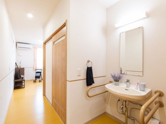 洗面台のある廊下 廊下 明るい空間に配置された洗面台は、介助用の手すりが設置されて安心です。シンプルで清潔なデザインの廊下です。