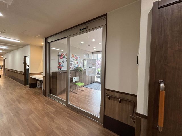 広い廊下とエントランス エントランス 明るいエントランスの隣には、広々とした廊下が用意されています。利用者の方々がリラックスできる空間です。