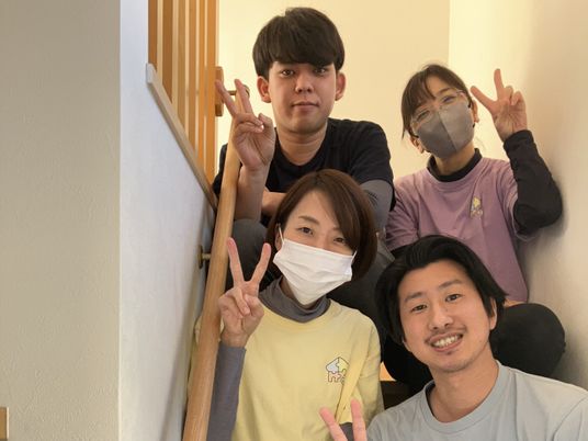 笑顔のスタッフが階段で集合した様子  