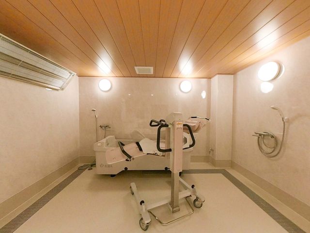 清潔な浴室 浴室 利用者の方が安心して使用できる広々とした設備が整っています。木目調の天井が和やかさを演出します。