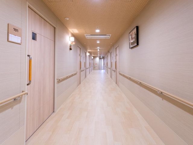 長い廊下 廊下 広々とした廊下には手すりが備えられており、安全に配慮されています。柔らかな照明が心地よいです。
