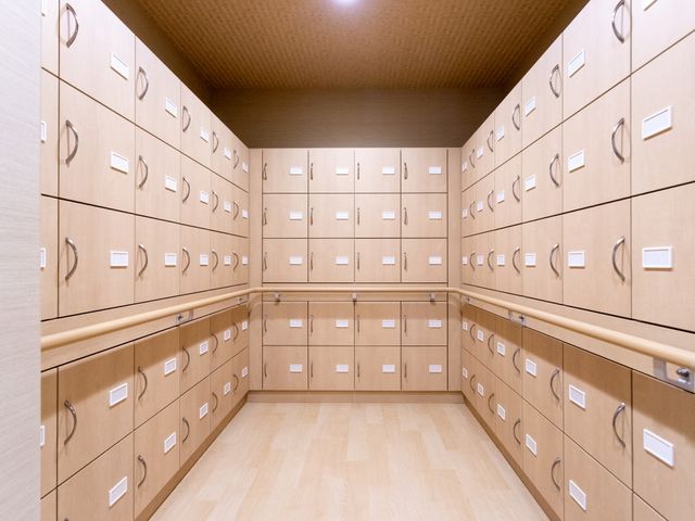鍵付き収納が並ぶ部屋 多目的室 鍵付きの収納が整然と並び、使い勝手の良さが特徴です。配置された手すりで安全性も確保されています。
