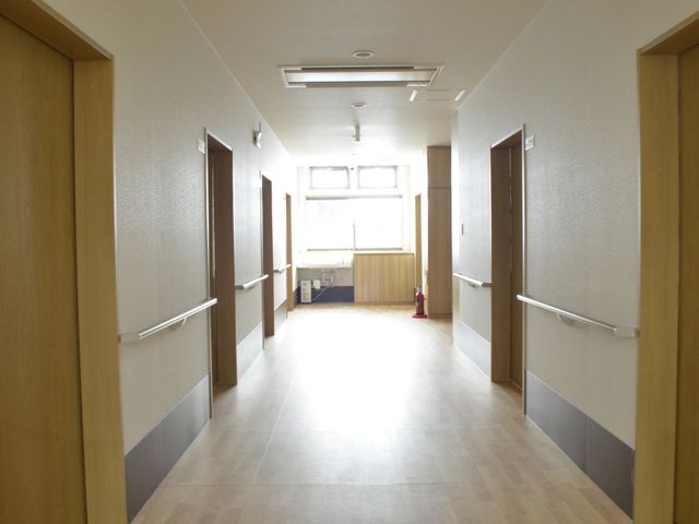 自然光あふれる廊下 廊下 窓から自然光が入り、明るく清潔感ある通路です。転倒防止のための手すりが設置されています。