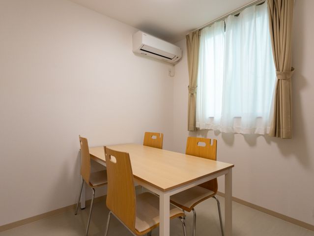 自然光が入る部屋 多目的室 暖かい日差しが入る空間です。木製のテーブルと椅子があり、会話や活動に最適です。