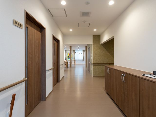広い通路 廊下 自然光が差し込む広々とした通路です。手すり付きで、安全に移動できる環境が整っています。