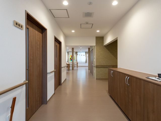 広い通路 廊下 自然光が差し込む広々とした通路です。手すり付きで、安全に移動できる環境が整っています。