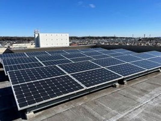 屋上の太陽光パネルと建物外観  