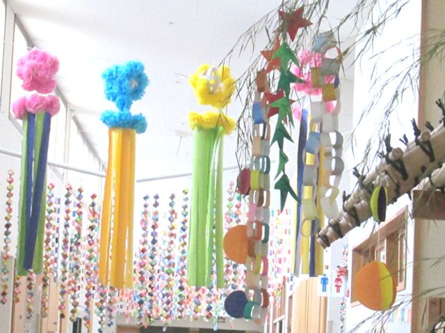 中庭の飾り付け 中庭 色とりどりの飾りが天井に垂れ下がり、暖かい雰囲気の共有空間を演出しています。癒やしと潤いを提供する環境です。