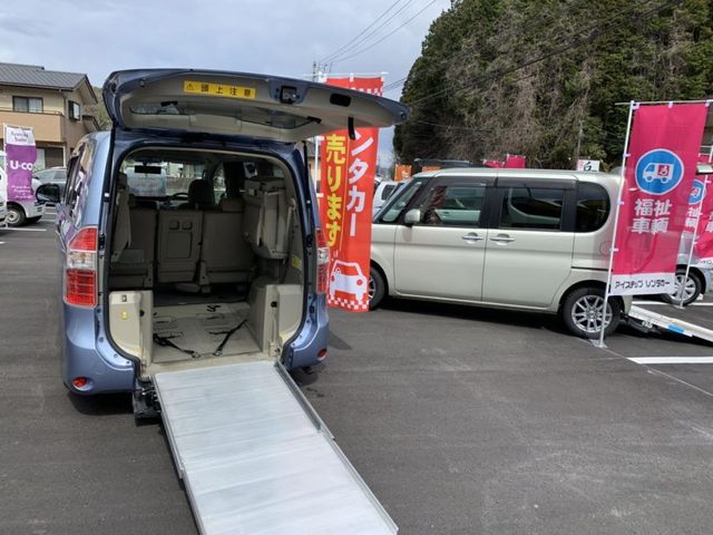 福祉車両展示場 外観   車椅子のまま乗り降りしやすいスロープ付きの福祉車両が並んでいます。送迎体制を重視する職場づくりの参考になります。